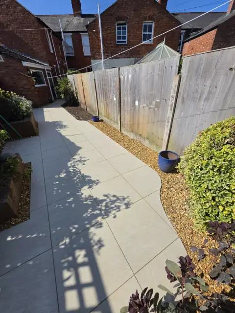 The same garden finished with a curved porcelain walkway and gravel borders