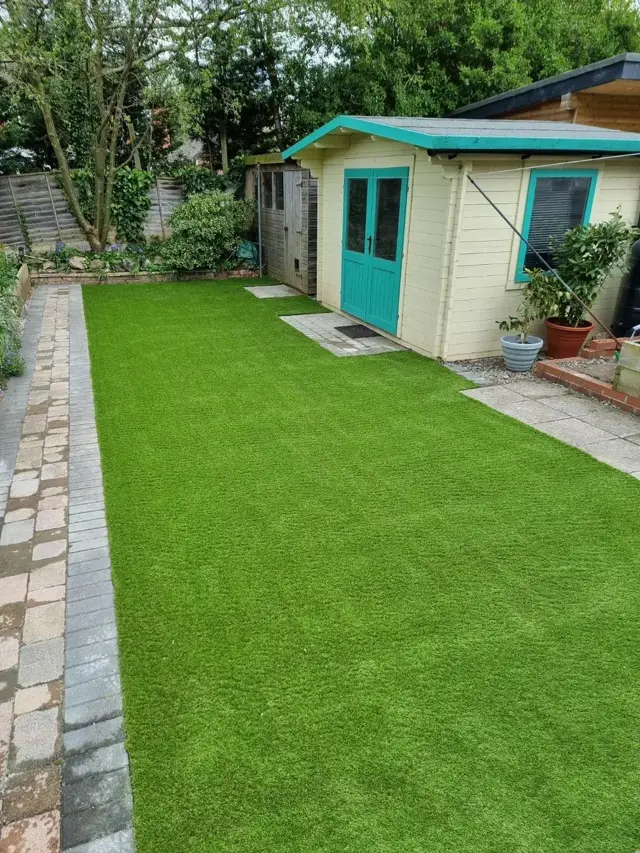 Artificial grass lawn with paved edging and summerhouse – The Green Team, Shropshire
