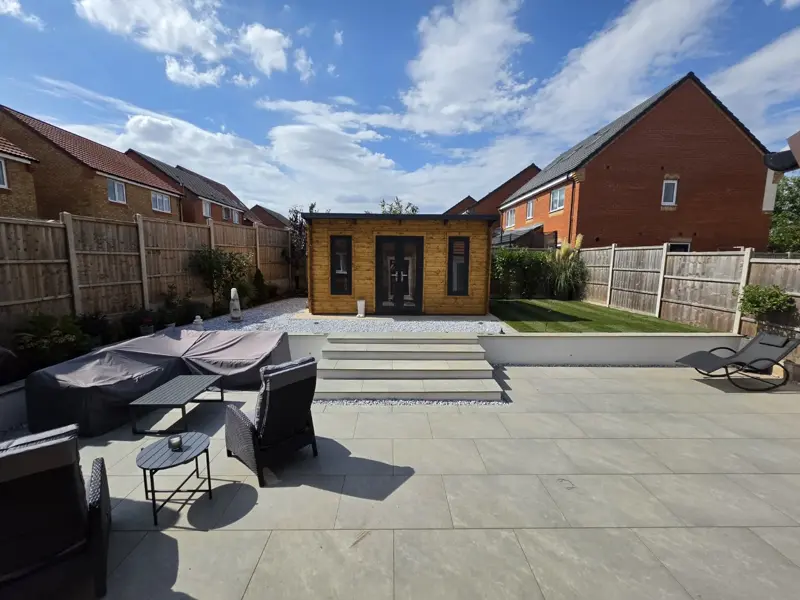 Full garden landscaping with porcelain patio, steps, lawn and garden room